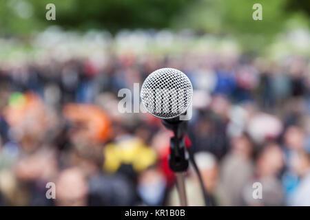 Microfono a fuoco contro pubblico sfocata. Protesta. Foto Stock