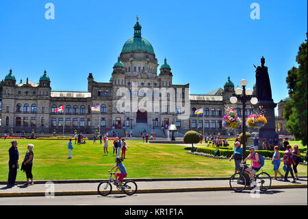 Una vista degli edifici legislativa in Victoria B.C., Canada con persone sulla parte anteriore motivi e marciapiede Foto Stock