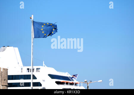 Un ragged, strappata, spiacenti cercando e battuto bandiera dell'Unione europea battenti in un vento forte sull' isola di Rodi, Grecia Foto Stock