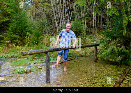 Uomo di Kneipp, a piedi nudi in acqua Percorso Kneipp a Schmelzerbach, Inzell, Chiemgau, Alta Baviera, Baviera, Germania Foto Stock