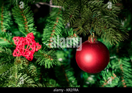 Close up red ninnolo su artrificial albero di Natale Foto Stock