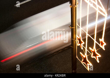 Strada di natale decorazione luce in una piovosa notte di dicembre a Belgrado in Serbia e una vettura accelerando in motion blur sulla strada da sopra Foto Stock