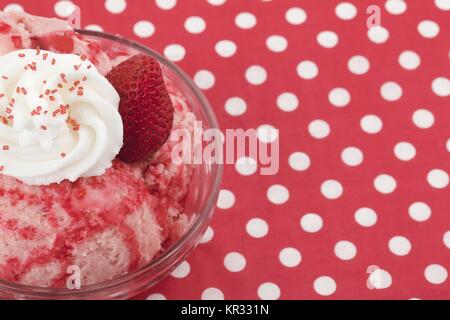 Gelato alla fragola con condimenti sul recipiente Foto Stock