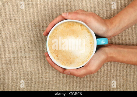 Due donna mani cappuccino tazza da caffè Foto Stock