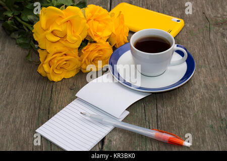 Ancora vita bouquet di rose di colore giallo, il caffè e il portatile Foto Stock