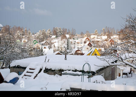 Insediamento suburbano di piccole case di legno inverno vista sui tetti coperti di neve Foto Stock