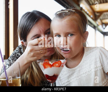 Mom alimenta la figlia di gelato Foto Stock