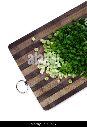 Green le cipolle tritate su un tagliere Foto Stock