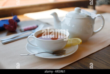 Tazza di tè con limone e teiera Foto Stock