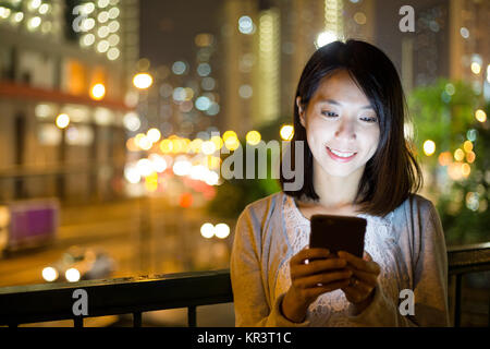 Donna uso del telefono cellulare durante la notte Foto Stock