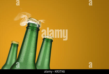 Verde tre bottiglie di birra su sfondo giallo Foto Stock