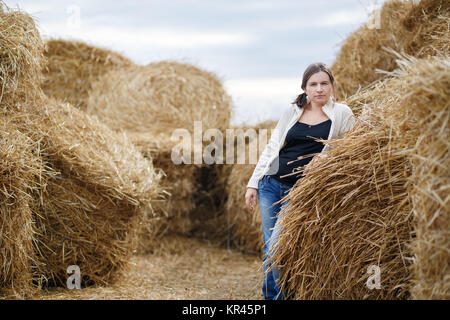 Donna e Haystacks Foto Stock