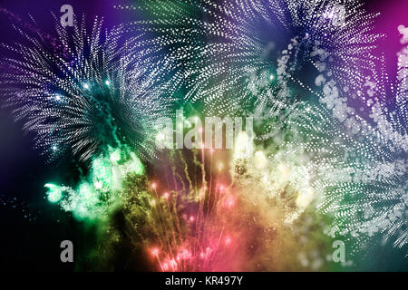 Nächtliches Feuerwerk mit bunten Licht- und Glitzermustern, grafische Sternformen mit Bewegungsunschärfe hinzugefügt Foto Stock