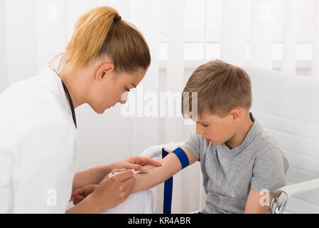 Medico tenendo il campione di sangue del paziente per bambini Foto Stock