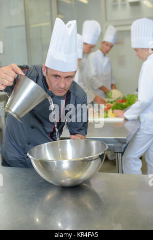 Lo Chef versare acqua in vaso Foto Stock