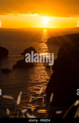 Tramonto sopra le rocce costiere con wild highl Foto Stock