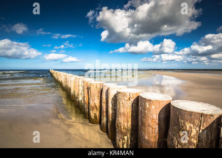 I frangiflutti in legno sulla sabbiosa spiaggia Leba nel tardo pomeriggio, Mar Baltico, Polonia Foto Stock