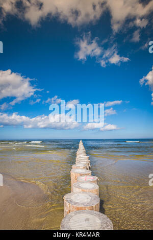 I frangiflutti in legno sulla sabbiosa spiaggia Leba nel tardo pomeriggio, Mar Baltico, Polonia Foto Stock