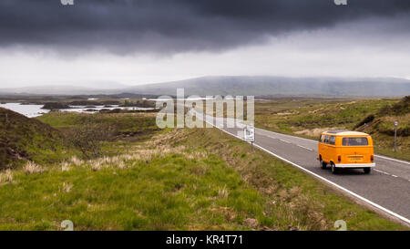 Glencoe, Scotland, Regno Unito - 4 Giugno 2011: un tradizionale VW Camper Van è tra il traffico che attraversa il tetro Rannoch Moor torbiera nelle Highlands Scotla Foto Stock