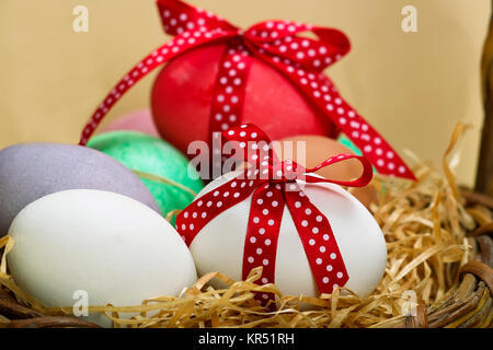 Osterei gepunkteter mit roter Schleife vor Tulpen uovo di pasqua con spotted loop rosso Foto Stock