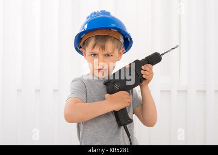 Ritratto di un ragazzo Holding trapano elettrico Foto Stock