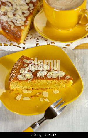 Ricotta torta di mandorle con mandorle e zucchero in polvere su di un piatto di legno Foto Stock