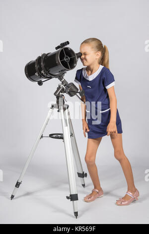 Giovani astronomo divertenti guarda attraverso l'oculare del telescopio Foto Stock
