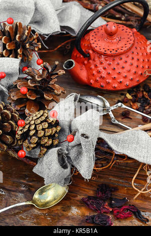 Rosso teiera in metallo,le foglie di tè e autunno pigne Foto Stock