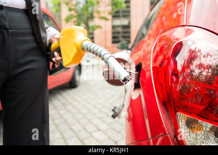 Close-up di imprenditrice la mano il rifornimento auto del serbatoio Foto Stock