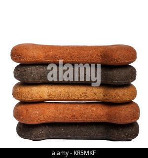 Una pila di osso di cane a forma di biscotti su sfondo bianco Foto Stock