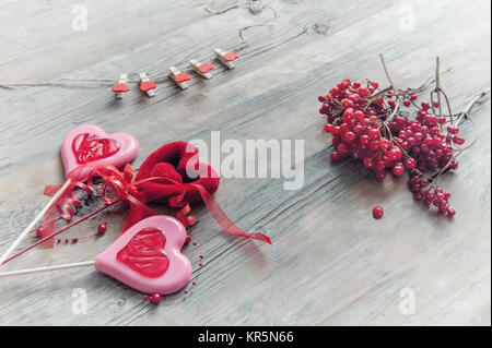 Due cuori di Dolce caramello su sfondo di legno ramo di bacche di pallon di maggio per il giorno di San Valentino. Foto Stock