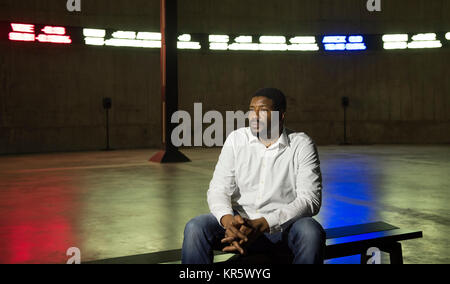 La Tate Modern di Londra, Regno Unito. Il 18 dicembre 2017. Il modo in cui le cose terrene sono in corso 2017, un coinvolgente e multi-installazione canali dall'artista nigeriano Emeka Ogboh (nella foto), è svelato. Questo lavoro è sul display da 18 dic 2017-4 Feb 2018 per la prima volta nel Regno Unito, il riempimento del sotterraneo vasca est nell'Edificio Blavatnik. Le funzioni di lavoro live-streaming di dati di borsa a scorrere lungo la circonferenza del serbatoio in 25 metri di rosso, verde e LED bianco visualizza. Credito: Malcolm Park editoriale/Alamy Live News Foto Stock