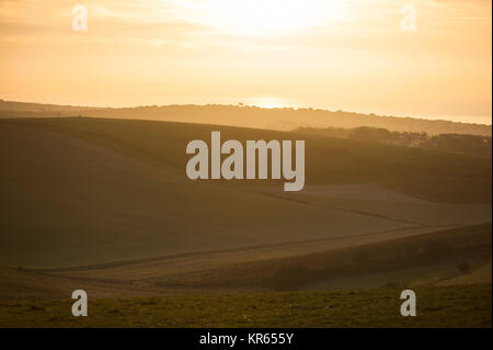 Brighton, East Sussex. 19 dicembre 2017. Regno Unito Meteo. La mattina presto dog walker e cavalieri a Brighton Racecourse e Sheepcote Valley testimonianza un incredibile tramonto sul South Downs National Park in un freddo gelido e mattina sulla costa sud. Credito: Francesca Moore/Alamy Live News Foto Stock