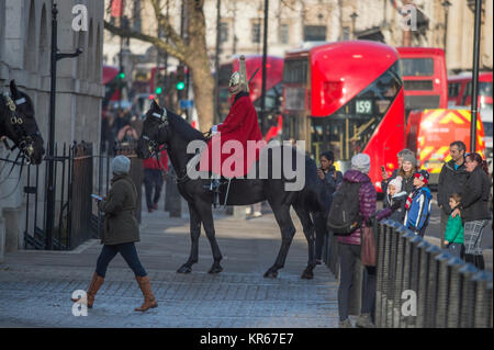 Whitehall, Londra, Regno Unito. Il 19 dicembre 2017. Una vita di protezione sulla mattina sentinella a Horse Guards ingresso porta il suo cavallo a razze torna alla garitta dopo che questa si sposta sul marciapiedi a Whitehall nella parte anteriore dei pedoni. Credito: Malcolm Park/Alamy Live News. Foto Stock