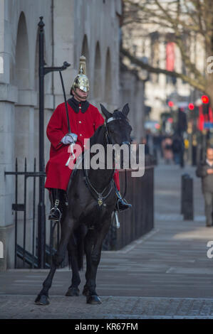 Whitehall, Londra, Regno Unito. Il 19 dicembre 2017. Una vita di protezione sulla mattina sentinella a Horse Guards ingresso porta il suo cavallo a razze torna alla garitta dopo che questa si sposta sul marciapiedi a Whitehall nella parte anteriore dei pedoni. Credito: Malcolm Park/Alamy Live News. Foto Stock