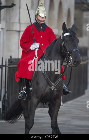 Whitehall, Londra, Regno Unito. Il 19 dicembre 2017. Una vita di protezione sulla mattina sentinella a Horse Guards ingresso porta il suo cavallo a razze torna alla garitta dopo che questa si sposta sul marciapiedi a Whitehall nella parte anteriore dei pedoni. Credito: Malcolm Park/Alamy Live News. Foto Stock