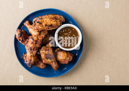 Teriyaki ali di pollo con la salsa sul piano del tavolo Foto Stock