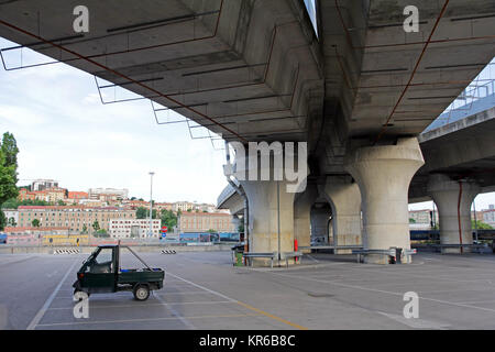 Un ape furgoni sotto un ponte in Italia Foto Stock