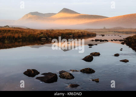 Autunno sunrise vede il nord del monte Nero riflesso in Loch Ba su Rannoch Moor, Highlands della Scozia Foto Stock