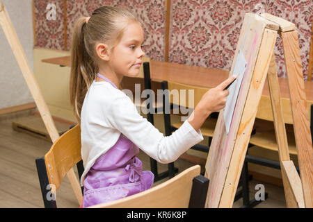 Ragazza artista con un sorriso guardare nella foto sulla lezione di disegno Foto Stock