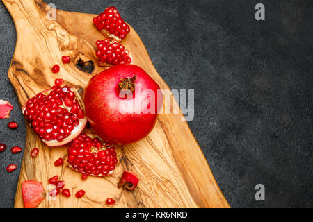 Il Melograno e semi di close-up scuro su sfondo di calcestruzzo Foto Stock