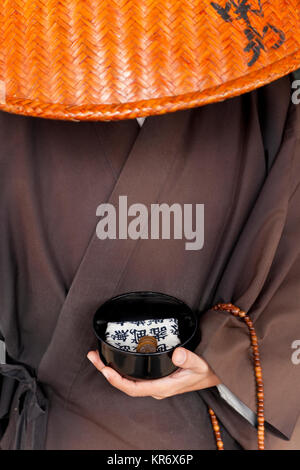 Chiusura del monaco giapponese indossa abbigliamento tradizionale azienda alms ciotola. Foto Stock