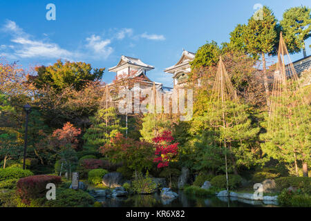 Giardino paesaggistico in autunno con alberi, stagno e pagode in background. Foto Stock