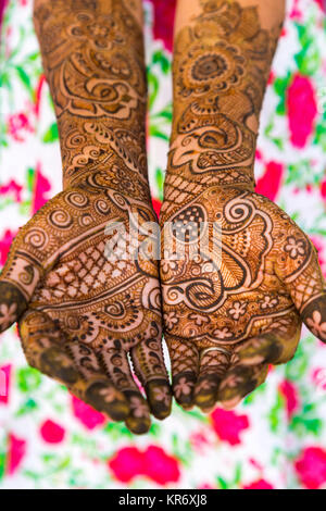 Angolo alto close up di mani femminili coperto di Henna Tattoos con intricati, geometrici e floreali foliate pattern. Foto Stock