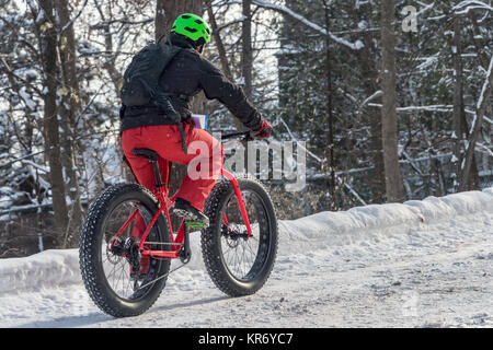 Montreal, CA - 17 dicembre 2017 un uomo è a cavallo di un fat tire snow bike di Mont Royal Park. Foto Stock
