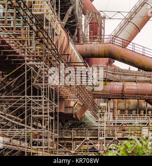 Weathered arrugginito scenario industriale con il vecchio corroso le travi in acciaio e tubi in metallo Foto Stock