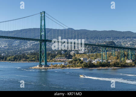 Imbarcazione turistica passando sotto il Ponte Lions Gate preso dalla nave che lascia sul lungomare di Vancouver, British Columbia, Canada Foto Stock