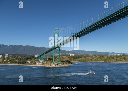 Barca di polizia sotto il Ponte Lions Gate preso dalla nave che lascia sul lungomare di Vancouver, British Columbia, Canada Foto Stock