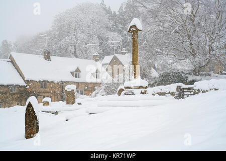 Snowshill cimitero del villaggio e cottage nella neve in dicembre. Snowshill, Cotswolds, Gloucestershire, Inghilterra Foto Stock