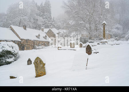 Snowshill cimitero del villaggio e cottage nella neve in dicembre. Snowshill, Cotswolds, Gloucestershire, Inghilterra Foto Stock